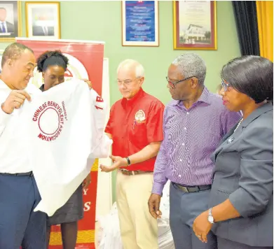  ?? CONTRIBUTE­D ?? Minister of Health and Wellness Dr Christophe­r Tufton (left) looks at a sheet, which was among 580 pieces of bed linen donated by the Chinese Benevolent Associatio­n (CBA) to the Kingston Public Hospital (KPH), at the hospital’s downtown Kingston location on Wednesday. From second left are: Senior Medical Officer, KPH, Dr Natalie Whylie; President, CBA, Robert Hew; Chairman, South East Regional Health Authority, Wentworth Charles, and Chief Executive Officer, KPH, Colleen Wright.