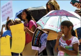  ??  ?? A 6-year-old Brawley girl watches the crowd in attendance while standing under an umbrella to protect her from the sun during the Imperial Valley Social Justice Committee’s peaceful rally held Saturday outside the Imperial Regional Detention Facility in Calexico. VINCENT OSUNA PHOTO