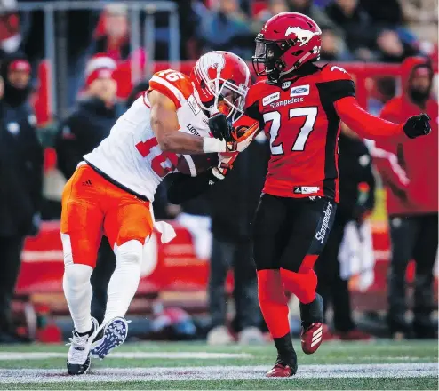  ?? — THE CANADIAN PRESS ?? The Lions’ Bryan Burnham manages to catch and hang on to the ball as Calgary’s Tunde Adeleke tries to knock it free during Saturday night’s game at McMahon Stadium in Calgary.