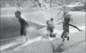  ?? By Steven Senne, AP ?? First day of summer: Solaris Arias, 4, right, jumps through water spraying from an open fire hydrant in Providence.