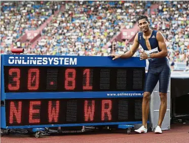  ??  ?? Heir apparent:
Wayde Van Niekerk of South Africa posing next to the display with his time as he celebrates his victory in the 300m at the Golden Spike meeting in Ostrava, the Czech Republic, on Wednesday. – AP