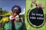  ?? ERALDO PERES — THE ASSOCIATED PRESS ?? An reveler in costume attends the Pacotao street carnival party whose theme this year is The Mad President in Brasilia, Brazil, Sunday. The poster shows Brazil’s President Michel Temer with a cross and phrase in Portuguese protesting reform of the...