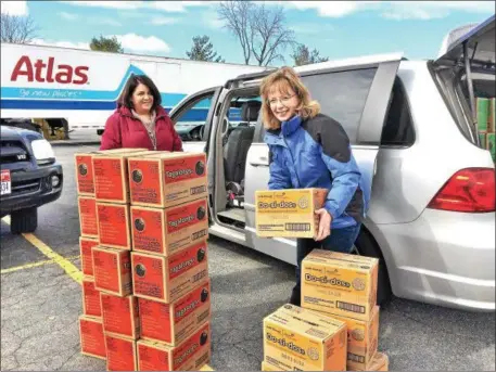  ?? PHOTOS BY GLENN GRIFFITH — GGRIFFITH@DIGITALFIR­STMEDIA.COM ?? Amy Williams, left, and Michele Kuhns, right, make sure they have the correct number of Girl Scout cookies for Troop 2429after making a cookie pickup Friday in Clifton Park.