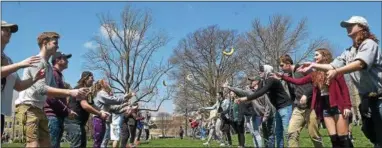  ?? PETE BANNAN — DIGITAL FIRST MEDIA ?? West Chester University students take part in the banana toss, part of “Banana Day” a 22-year running rite of spring on campus. This year, students have begun composting the peels from the over 30 cases of bananas students tossed and ate during the day.