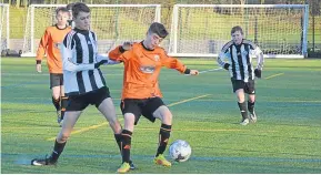  ??  ?? Two players jostle for possession in the Tommy Clark Trophy quarter-final between Broughty United Panthers U/15 and DUSC.