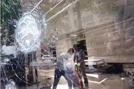  ?? Photograph: Scott Olson/Getty Images ?? Workers clean up inside of the Saint Laurent store after it was looted on 10 August in Chicago.