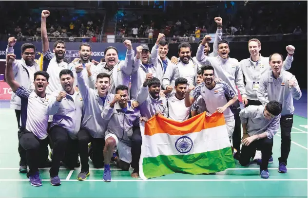  ?? Associated Press ?? ↑
India’s team members pose with their national flag after winning the Thomas Cup title in Bangkok on Sunday.