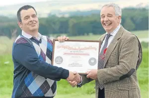  ??  ?? Tom McMath, left, was recognised for his 40 years of work with J&amp;A Steel, of Craignathr­o Farm, Forfar. He was given the honour from his employer, Andrew Steel, who is also president of Kirriemuir Show.