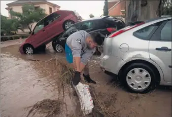  ?? JORGE GUERRERO / AGENCE FRANCE-PRESSE ?? A man removes debris from a flooded street in Campillos, near Malaga, on Sunday, after heavy rain hit southern Spain.