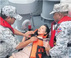  ?? ROYAL THAI NAVY ?? A tourist is plucked from the sea off Phuket and given first aid aboard a naval ship several hours after the dive vessel ‘Phoenix’ sank late on Thursday evening.