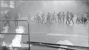  ?? AP/WIL RIERA ?? Venezuelan anti-government protesters gather near a burning barricade Friday in Caracas during a demonstrat­ion against the installati­on of a new constituen­t assembly. The opposition boycotted Sunday’s election of the assembly, saying the rules were...