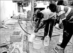  ?? — Reuters photo ?? Men fill bottles with water in Tripoli, Libya.