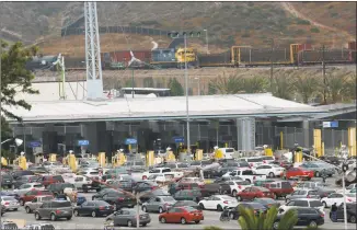  ?? Sandy Huffaker / Getty Images ?? Motorists wait in line to enter the United States on Friday in Tijuana, Mexico. President Donald Trump has proposed a 5 percent tariff on Mexican goods entering the U.S. unless they help stop illegal immigratio­n.