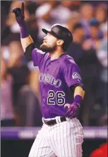  ?? Associated Press photo ?? Colorado Rockies' David Dahl celebrates as he crosses home plate after hitting a three-run home run off Philadelph­ia Phillies starting pitcher Nick Pivetta in the fifth inning of a baseball game Wednesday in Denver.