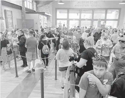  ?? PHOTOS BY DEWAYNE BEVIL/ORLANDO SENTINEL ?? World of Disney customers line up to pay for merchandis­e at the newly remodeled Disney Springs store Saturday.