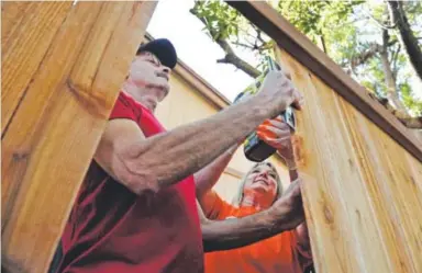  ??  ?? Bob Bostow and Darci Cress work together to install a fence for Dyanna Aragon on Tuesday at her home in Aurora. Team Depot, The Home Depot’s employee-led volunteer force, joined Denver’s VFW Post 1, the first VFW establishe­d in the world, to transform...