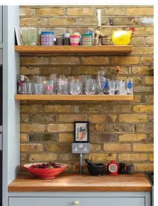  ?? ?? To really make a feature of her exposed brick wall, Jenny opted for open shelving rather than overhead cupboards. The chunky wooden shelves are from Worktop Express
