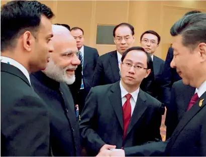  ?? PTI ?? Prime Minister Narendra Modi and Chinese President Xi Jinping exchange greetings at the BRICS leaders’ informal gathering hosted by the China, in Hamburg, Germany on Friday. —