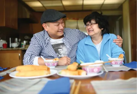  ?? COLE BURSTON FOR THE TORONTO STAR ?? Chef Nick Liu of the restaurant Dailo and his mother, Edith Liu, share a meal of congee, bok choi and Chinese fried dough. He says congee is the dish that reminds him most of home.