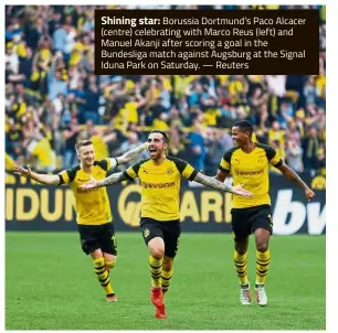  ??  ?? Shining star: Borussia Dortmund’s Paco Alcacer (centre) celebratin­g with Marco Reus (left) and Manuel Akanji after scoring a goal in the Bundesliga match against Augsburg at the Signal Iduna Park on Saturday. — Reuters