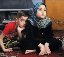 ?? (AP/Vahid Salemi) ?? Afghan refugees Salehe (right) and Shahrzad listen to their mother during an
interview with The Associated Press on April 21.