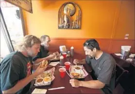  ?? Francine Orr Los Angeles Times ?? LUNCHTIME DINERS have a bite at Smokin’ Jonny’s BBQ.