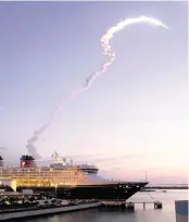  ?? DAVID ROARK Walt Disney Co., file ?? Space shuttle Atlantis lifts off from Cape Canaveral, rising above the Disney Magic cruise ship docked at its Port Canaveral cruise terminal.
