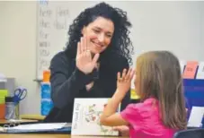  ?? Paul Aiken, Longmont Times-Call ?? Cara Mentzel gives a high-five to her student Lila Robbie for her reading during class at Foothill Elementary on Oct. 6.