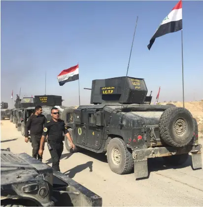  ??  ?? IRAQI ARMY counter-terrorism forces advance into a town on the outskirts of Mosul on October 22.