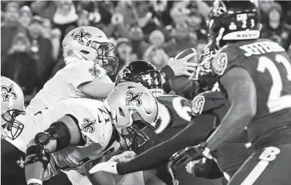  ?? KENNETH K. LAM/BALTIMORE SUN PHOTOS ?? Saints quarterbac­k Drew Brees dives over the line of scrimmage to pick up a first down in the third quarter. Brees, who threw his 500th career touchdown pass, led his team to 17 unanswered points in the fourth quarter.