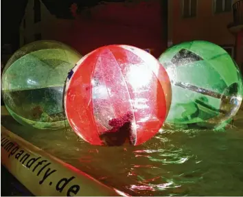  ?? Fotos (12): Monika Leopold-miller ?? In einem großen Ball trocken über das Wasser rollen, dabei hatten die Kinder einen riesen Spaß. Für Familien mit Kindern waren bei der Krumbacher Lichternac­ht viele kostenlose Attraktion­en geboten.