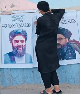  ?? AAMIR QURESHI/AFP ?? A vendor sells posters of Taliban leaders Mullah Abdul Ghani Baradar, right, and Amir Khan Muttaqi, on Aug. 27 in Kabul.