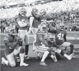  ?? TONY AVELAR AP ?? San Francisco players celebrate and mug for photograph­ers after cornerback Richard Sherman, seated second from right, intercepte­d a pass against the Vikings on Saturday.