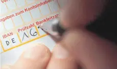  ?? FOTO: DPA ?? Handschrif­tliches Ausfüllen einer Überweisun­g: Von 2018 an soll überwiesen­es Geld in wenigen Sekunden beim Empfänger sein.