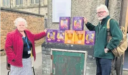  ??  ?? Eggs-ellent surprise Morag Rennie of Monklands Hospital estates department presents Easter eggs donated by staff to delighted Airdrie foodbank volunteer John Sheridan