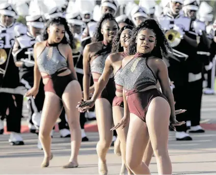  ?? Elizabeth Conley / Staff photograph­er ?? Motion of the Ocean dancers lead the members of Texas Southern University's Ocean of Soul marching band into the stadium before a recent football game.