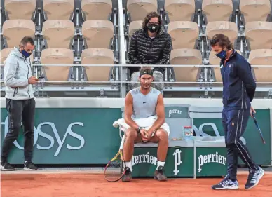  ?? AP ?? Spain's Rafael Nadal, center, coach Francisco Roig, right, and his staff gather during a break at the Roland Garros stadium during practice for the French Open in Paris on Friday.