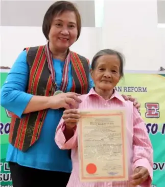  ?? Photo by Milo Brioso ?? LAND OWNERSHIP. Department of Agrarian Reform(DAR) Secretary Rosalina Bistoyong(left) turns over the certificat­e of land ownership to Molina Comila, 72 – years – old from Central Kapangan, Benguet. DAR distribute­d 937 hectares of agricultur­al land to...