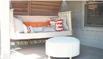  ?? MELANIE JOHNSON PHOTOGRAPH­Y PHOTOS/THE ASSOCIATED PRESS ?? A swing and pillows, as seen on this porch area designed by Abbe Fenimore, bring a touch of comfort to the outdoors.