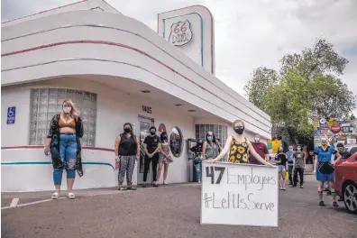  ?? ROBERTO E. ROSALES/JOURNAL ?? Staff members from 66 Diner on Central join the “Let Us Serve” protest Monday asking Gov. Michelle Lujan Grisham to reverse a newly reinstated ban on in-person dining at New Mexico restaurant­s and breweries.