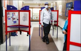  ?? JOHN MINCHILLO - ASSOCIATED PRESS ?? A polling worker walks among voting booths at a voting site inside Yonkers Middle/High School on Tuesday in Yonkers, N.Y.