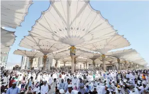  ??  ?? Hundreds of thousands of pilgrims perform prayer under the protective shade of giant umbrellas at the courtyard of the Prophet's Mosque in Madinah. (SPA)