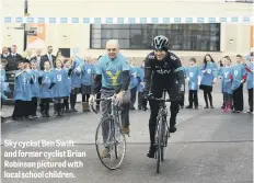  ??  ?? Sky cyclist Ben Swift and former cyclist Brian Robinson pictured with local school children.