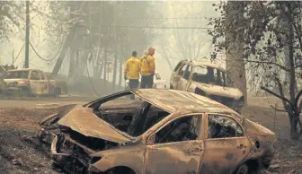  ?? AP ?? PERILOUS: Sonoma Valley firefighte­rs inspect burned out cars yesterday to make sure they are clear of human remains following a fire through a neighborho­od.