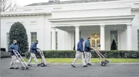  ?? DREW ANGERER / GETTY IMAGES ?? Workers roll dollies past the West Wing of the White House on Friday. According to recent news reports, President Donald Trump is slated to leave Washington the morning of Jan. 20, hours before President-elect Joe Biden will be sworn-in as president.