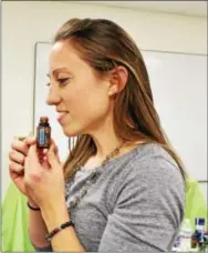  ?? MICHILEA PATTERSON — DIGITAL FIRST MEDIA ?? Amanda Bohn, wellness advocate for doTerra essential oils, smells the company’s Breathe product. The respirator­y blend includes coconut oil, lemon peel, cardamon seed and more.