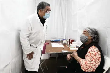  ?? SETH WENIG AP ?? Dr. Victor Peralta talks with Nellie Hernandez before giving her the second dose of a COVID-19 vaccine in New York on Feb. 5.