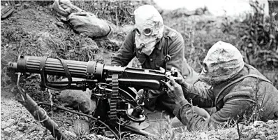  ??  ?? Sacrifice: British machine gunners wearing gas helmets during the Battle of the Somme in July 1916