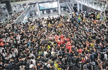  ?? Laurel Chor EPA/Shuttersto­ck ?? ANTI-GOVERNMENT protesters surround a man they accuse of being a mainland Chinese police officer during the fifth day of pro-democracy demonstrat­ions at Hong Kong’s internatio­nal airport.