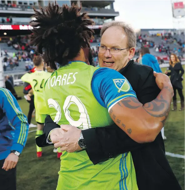  ?? — AP FILES ?? Sounders head coach Brian Schmetzer, shown hugging defender Roman Torres after a recent game, turned around the Seattle club’s fortunes by showing faith in the players and earning their respect. The Sounders face Toronto FC in Saturday’s MLS Cup.